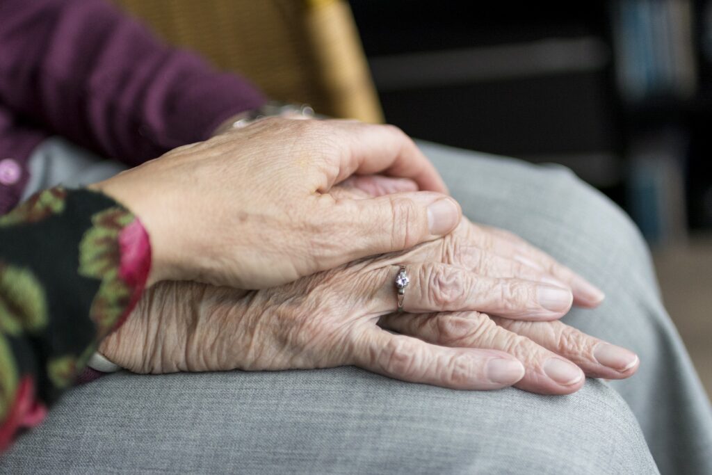 woman holding elderly woman's hands