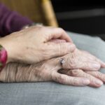 woman holding elderly woman's hands