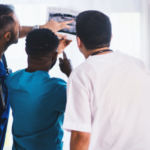 three medical professionals looking at x-ray results