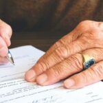 old man completing document