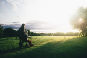 woman pushing elderly person in wheelchair outdoors