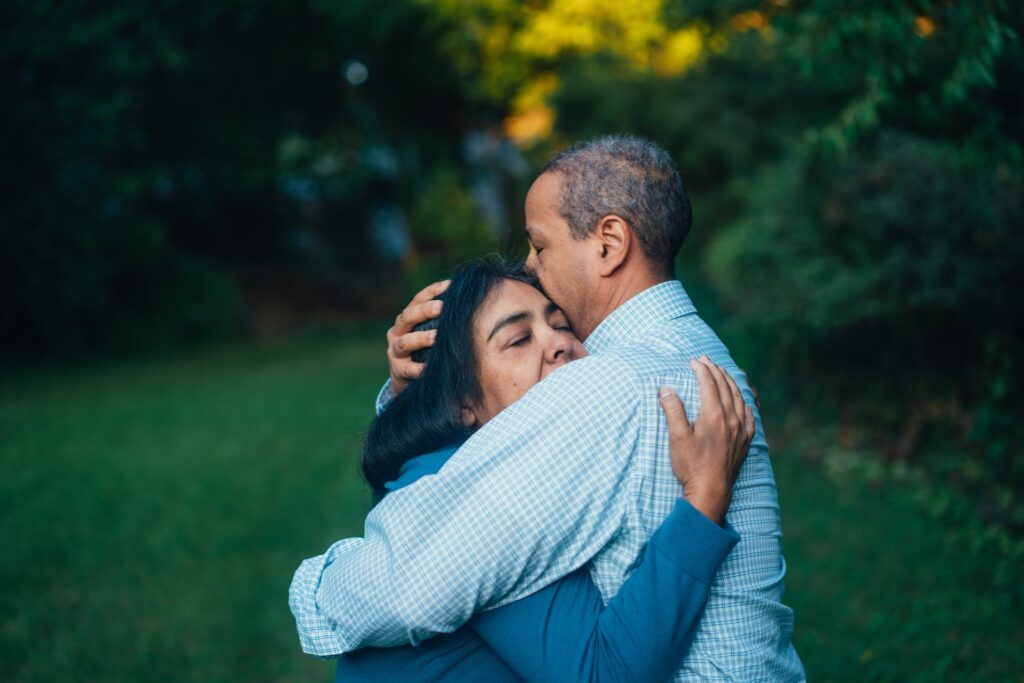 man hugging woman in backyard