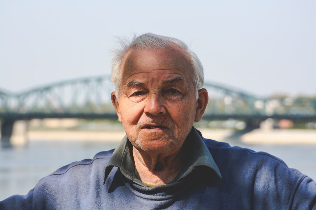 old man with river and bridge in background