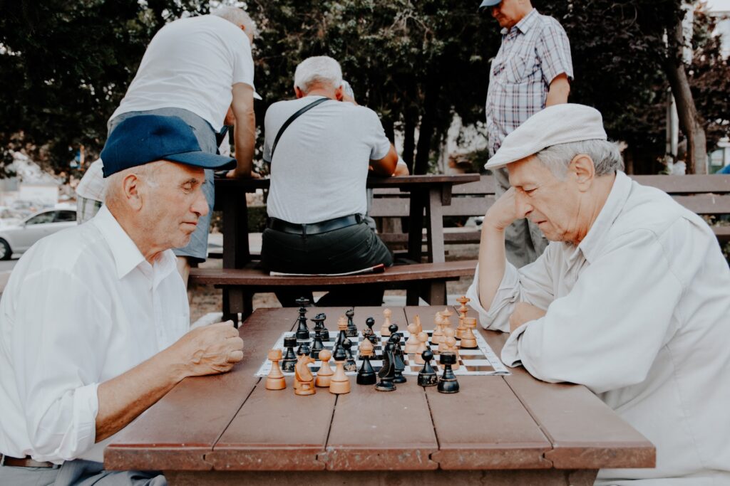 two old men playing chess in a park