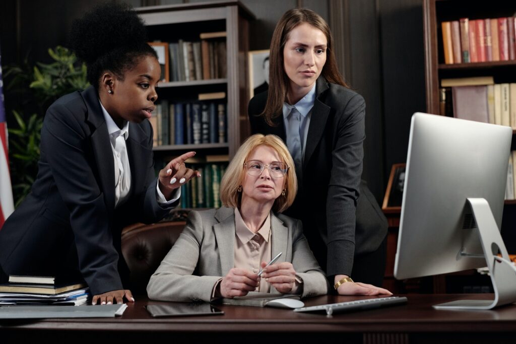 female attorneys gather around a computer in a law office