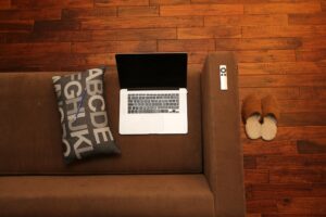 laptop on couch with hardwood floor background