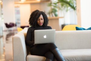 woman sitting on sofa with laptop