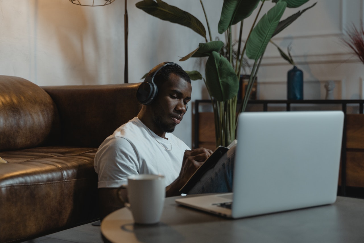 man in headphones working on tablet and laptop