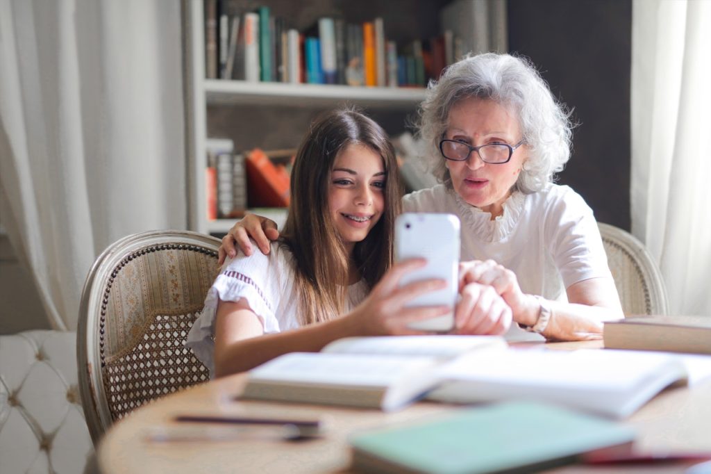 young woman showing her cellphone to her grandmother