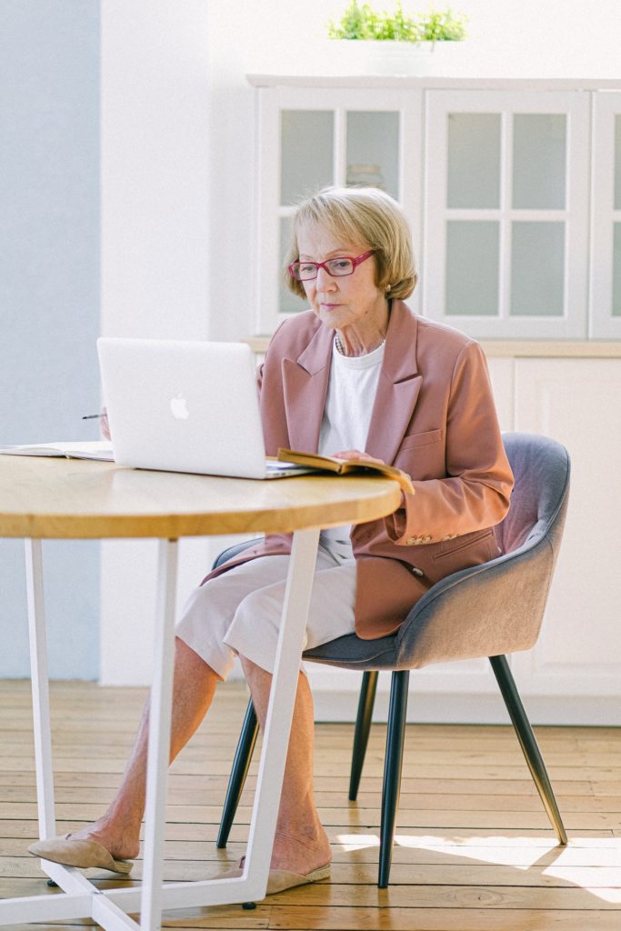 senior woman in eyeglasses working with laptop