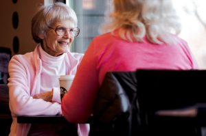 old woman sitting while talking with another woman