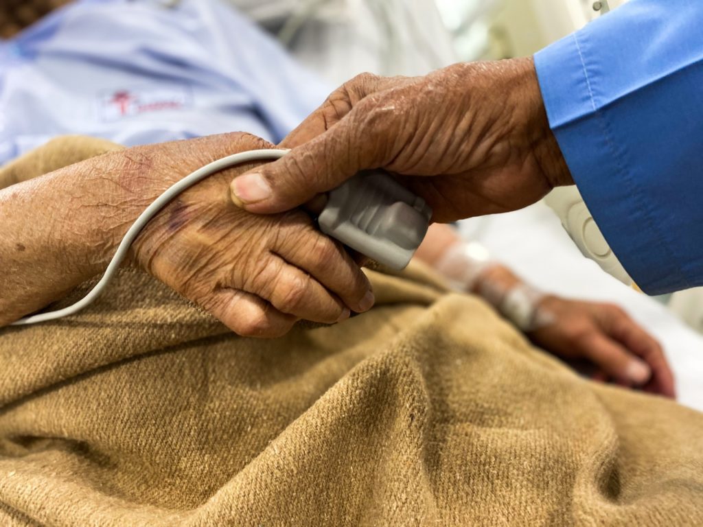 old couple holding hands in hospita