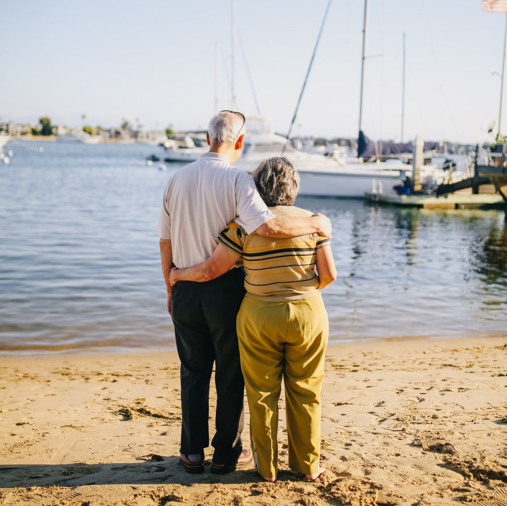 elderly couple standing on the shore