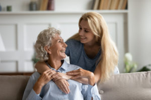 old woman and her middle-age daughter embracing and smiling