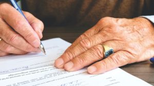 male hands signing a document