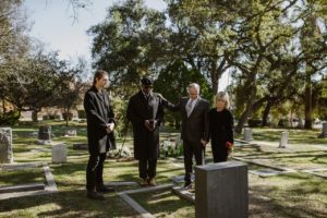 people standing around a gravesite after a funeral