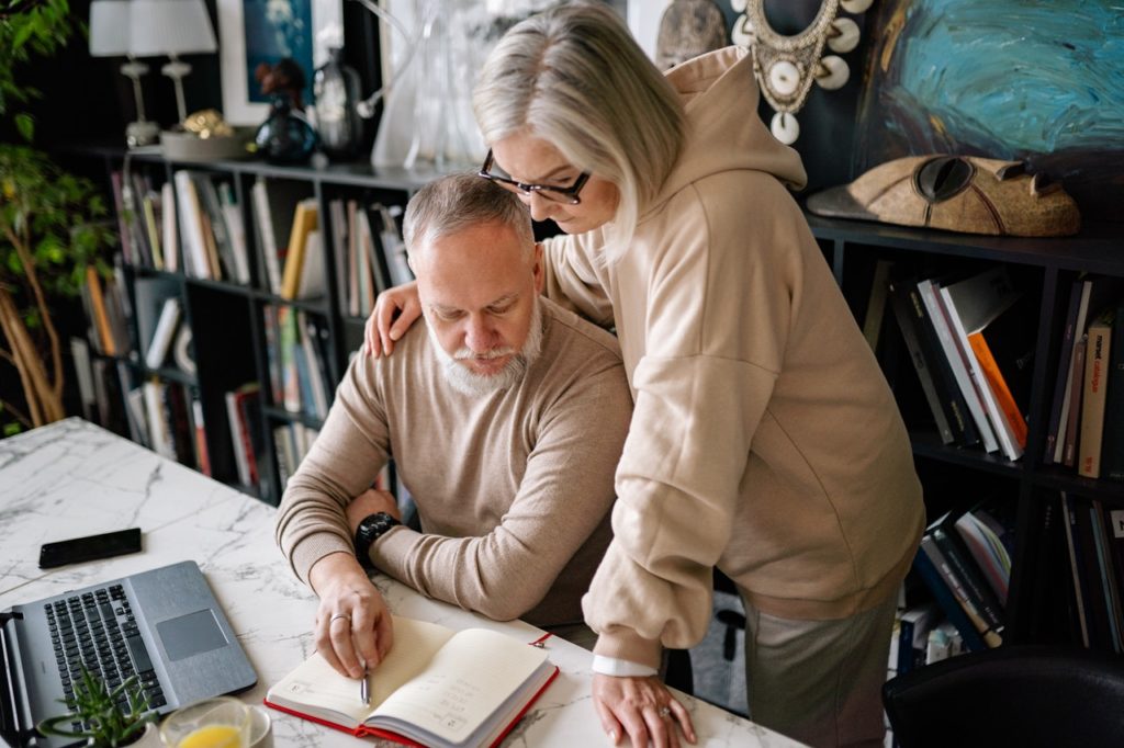 Old couple looking at desk looking at a book