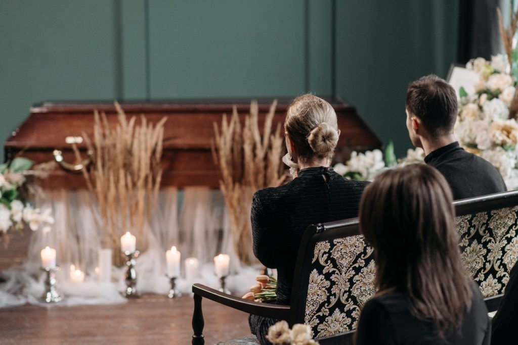 family sitting in front of coffin at a funeral