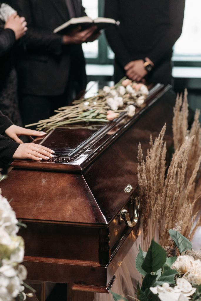 coffin with people around it at a funeral