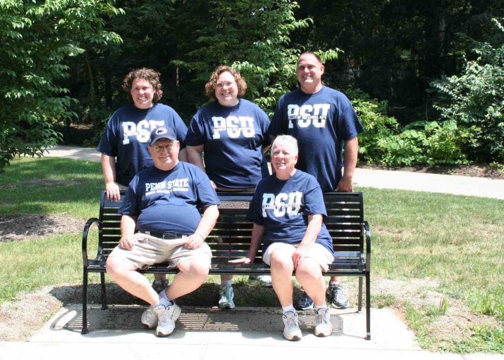 family sitting on a park bench
