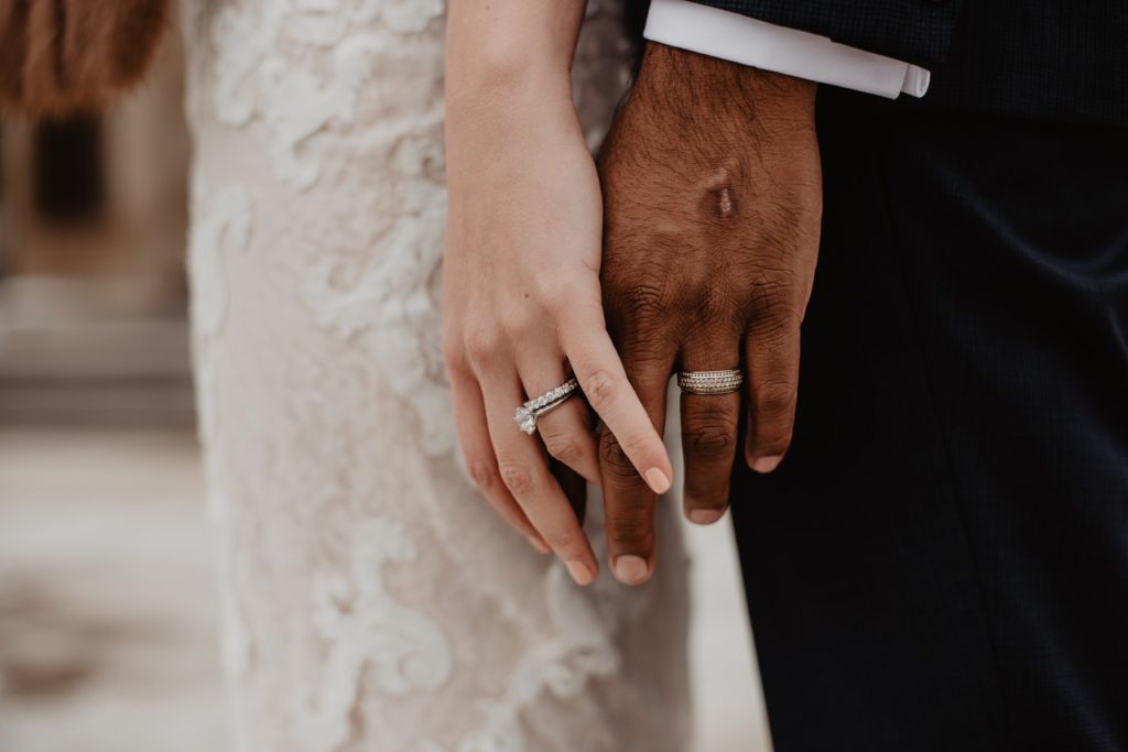 bride and groom touching hands on wedding day