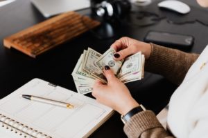 woman counting out US bills onto table