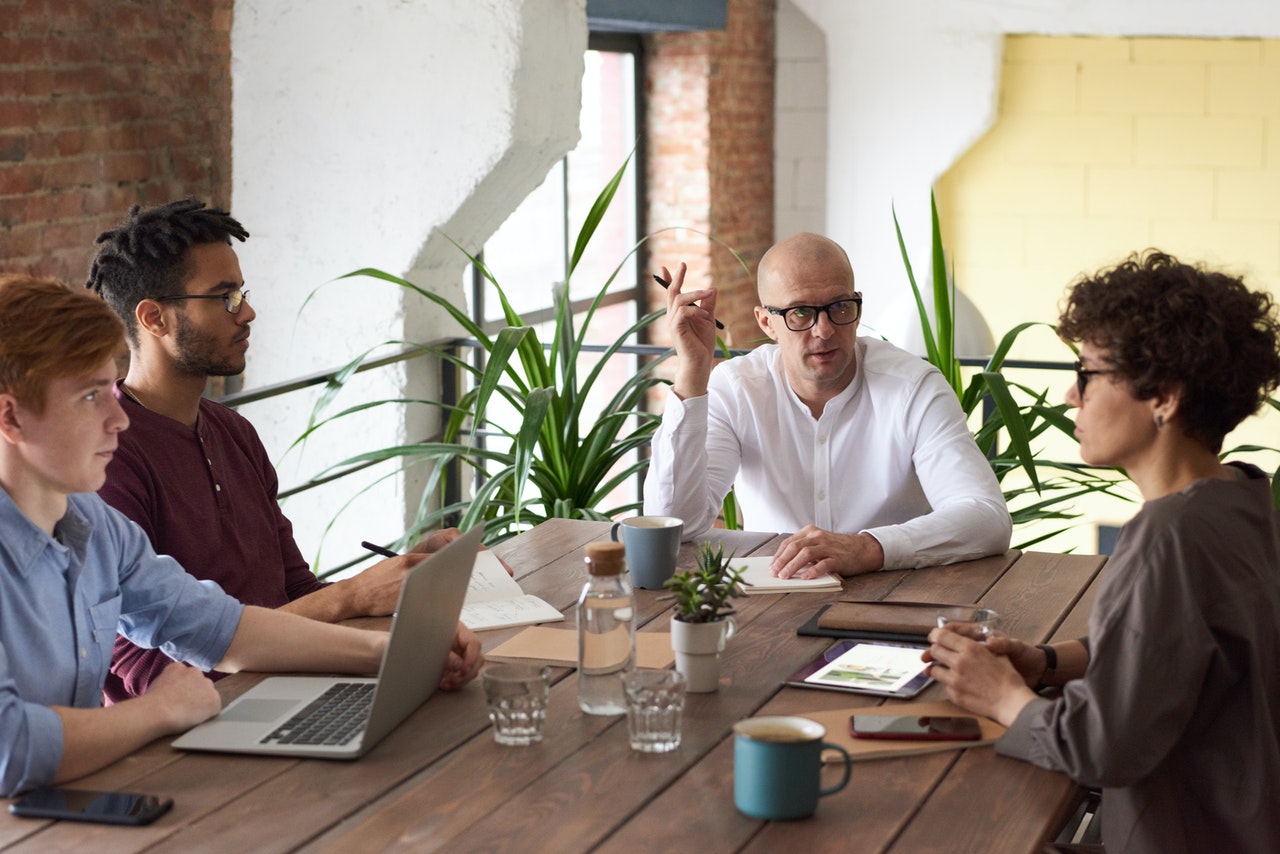 employees sit around a wood conference table