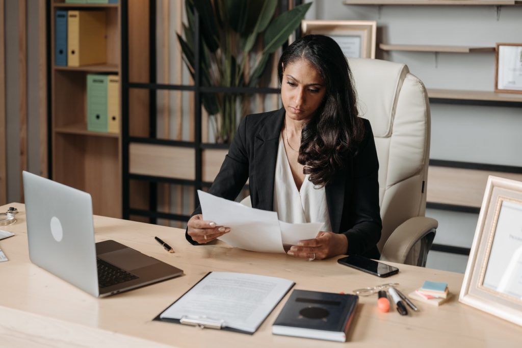 female attorney sits at desk reviewing documents