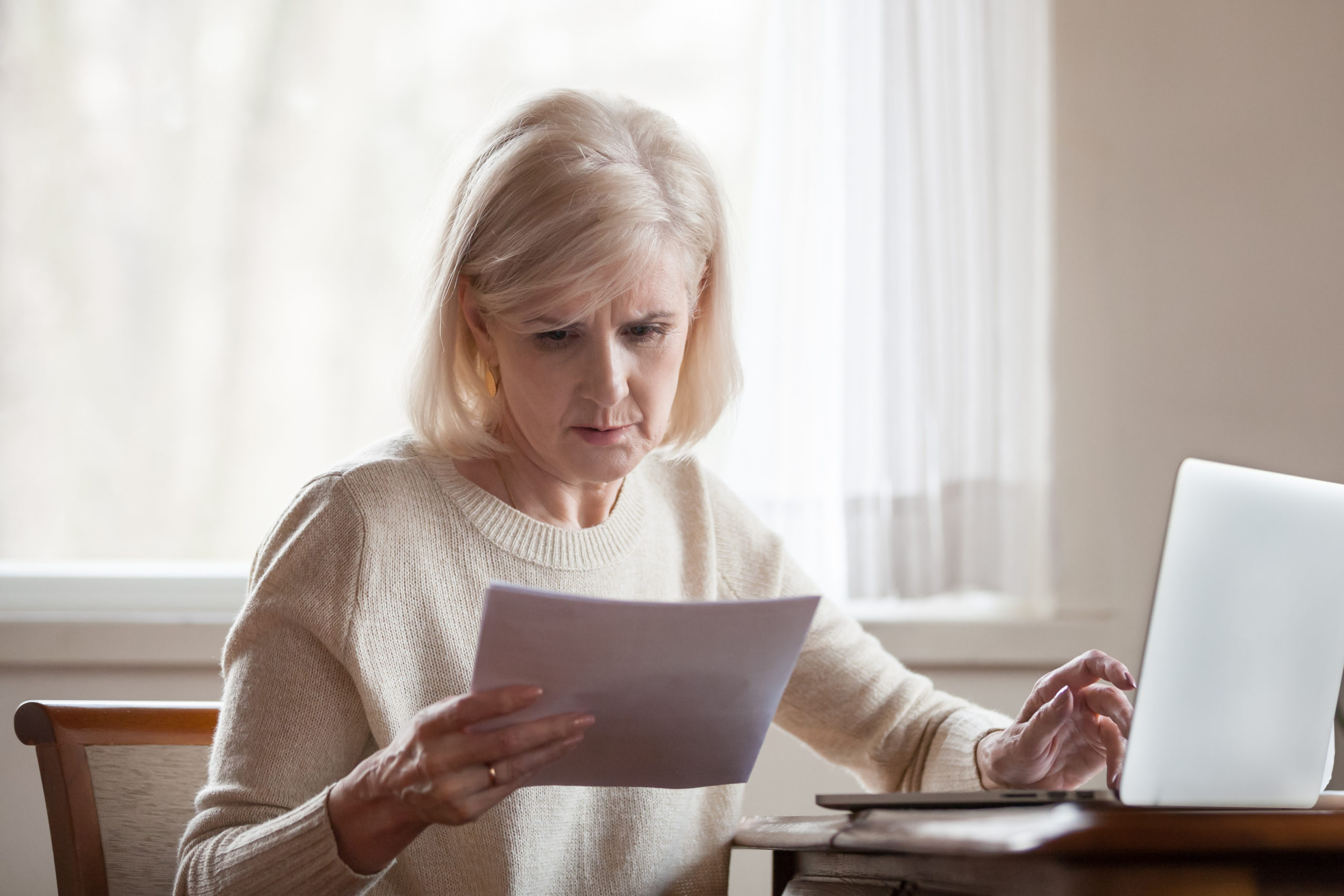 woman looking at documents with confused expression