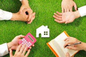 stock photo of house block with four pairs of hands