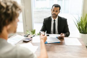 financial planner sits across from young millennial man